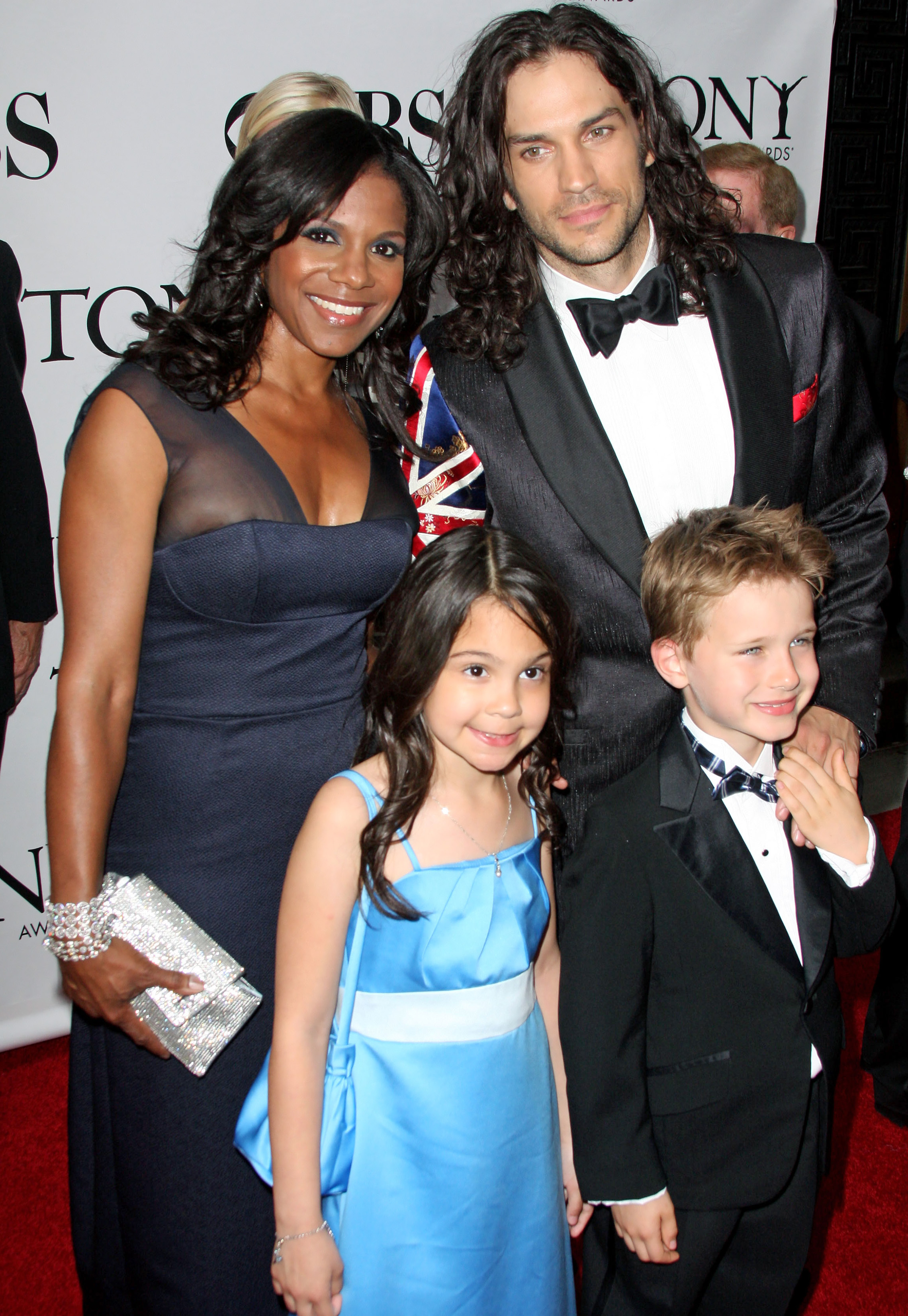 Audra McDonald and Will Swenson arrive at the 2012 Tony Awards ceremony, held at Radio City Music Hall in New York City. They are accompanied by Will's children from a previous marriage. (© Splash News/Splash News/Corbis)