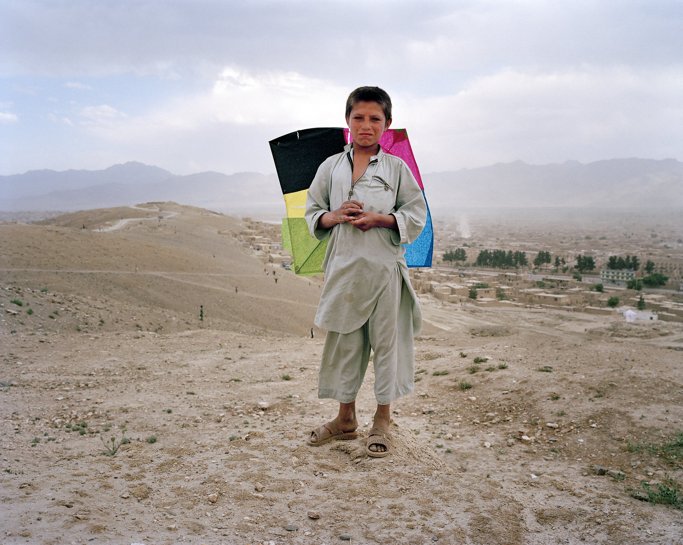 An Afghan boy flies a kite in the hills overlooking Kabul. Kite flying, the traditional sport of Afghan children, was banned under the fundamentalist Taliban regime, along with dancing, music, and a host of other activities. Reports of the kite flying ban inspired Khaled Hosseini to write his celebrated novel, The Kite Runner. Kites reappeared immediately when the Taliban was driven from Kabul. (© James Reeve/Corbis)