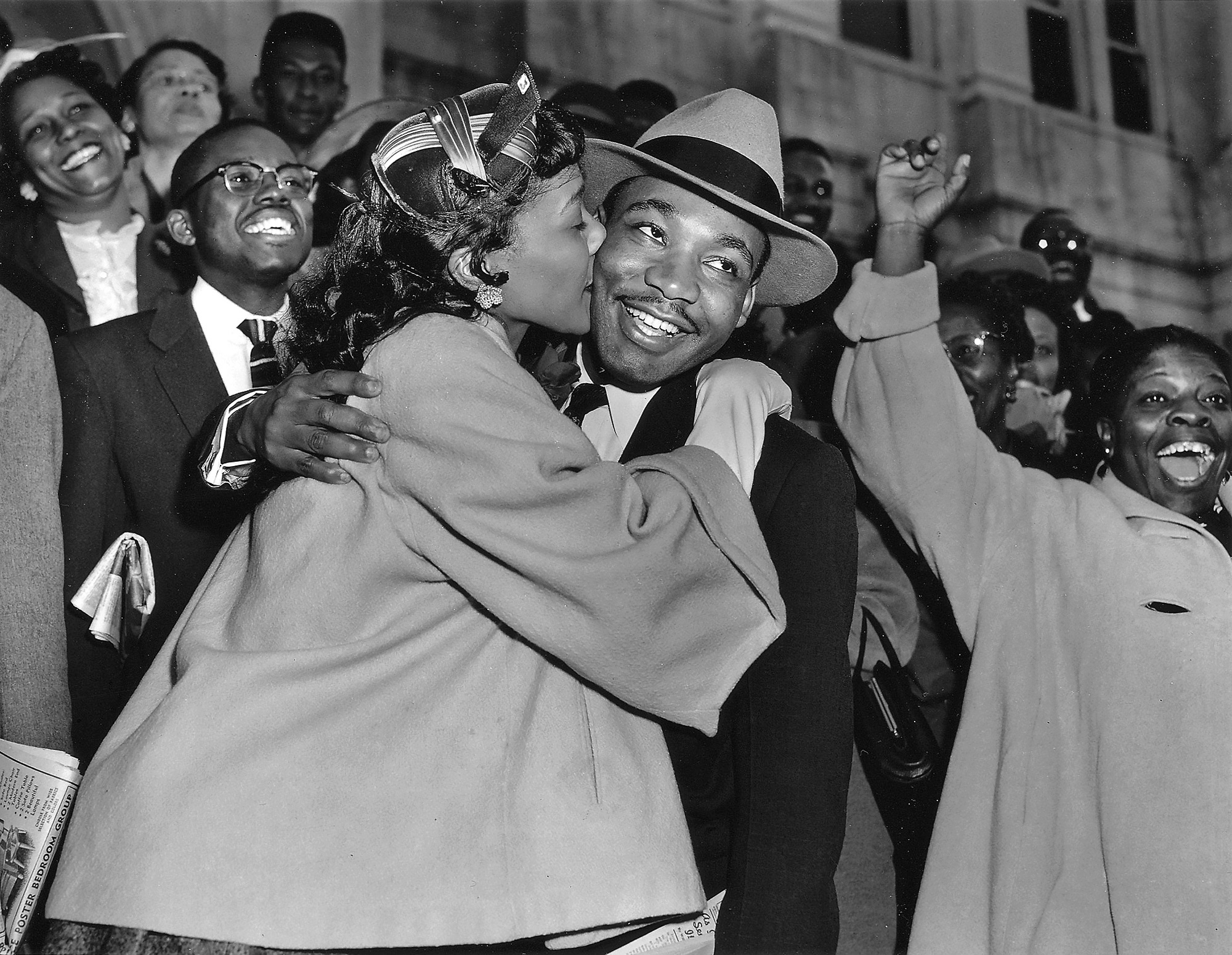 Coretta Scott King welcomes her husband, Dr. Martin Luther King, Jr., as he leaves the courtroom in Montgomery, Alabama, March 22, 1956. Dr. King was found guilty of conspiracy for leading a boycott of the city's segregated bus system. He ultimately spent two weeks in jail on the charge, attracting national attention to the boycott and the Civil Rights Movement. (AP Images/Gene Herrick)