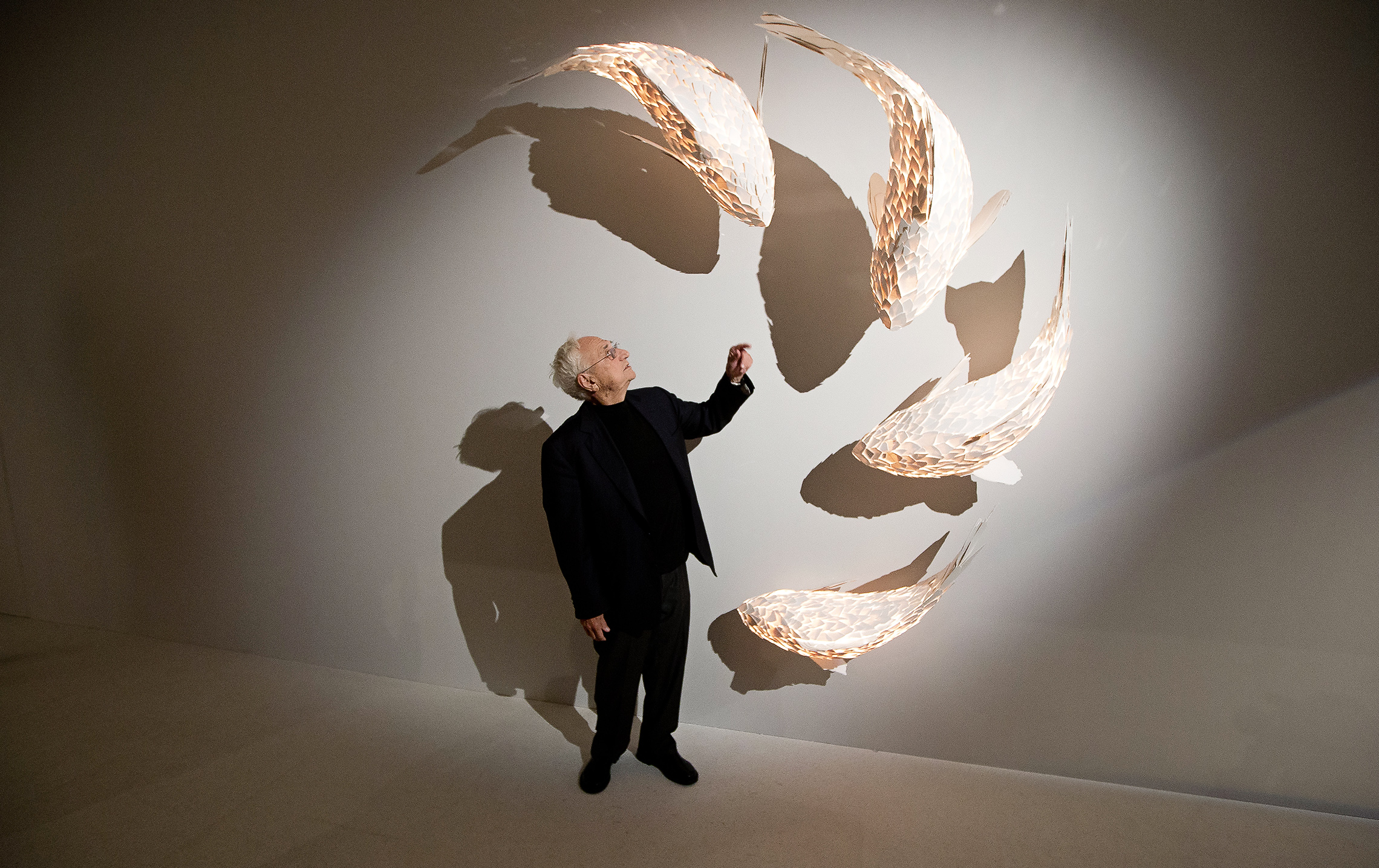 Canadian artist Frank Gehry, who has recently been announced as the architect to take on the redevelopment of Battersea Power Station, stands next his fish lamps at the opening of his exhibition at the Gagosian Mayfair gallery, in central London, Thursday, Nov. 7, 2013. (Photo by Joel Ryan/Invision/AP)