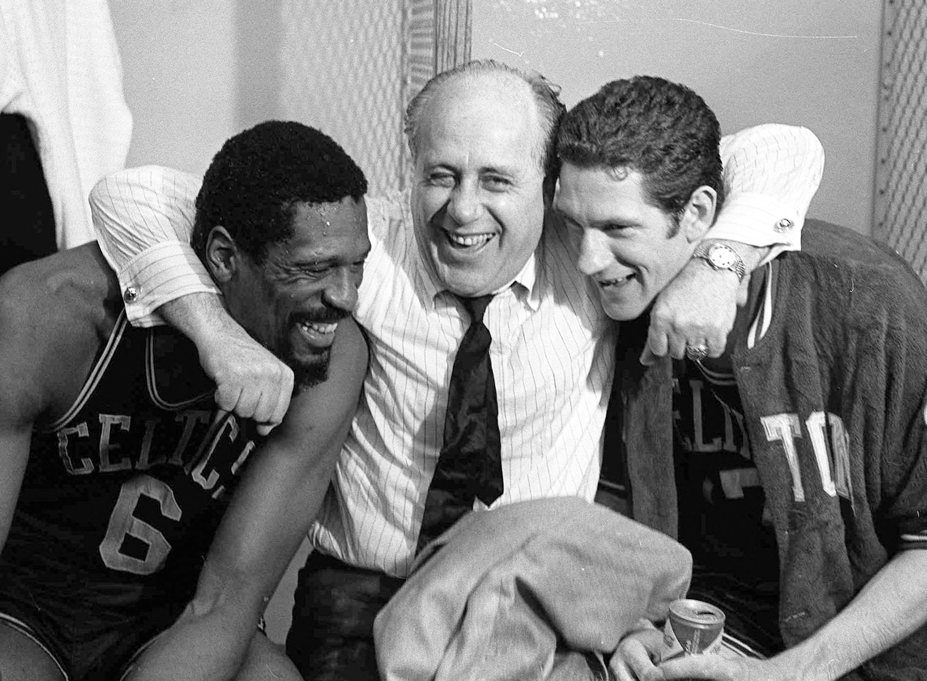 Celtics general manager Red Auerbach hugs Bill Russell and John Havlicek after their championship win over the Los Angeles Lakers in 1968. The longtime coach of the Celtics, Auerbach had hired Russell to replace him, with gratifying results. (AP Images)