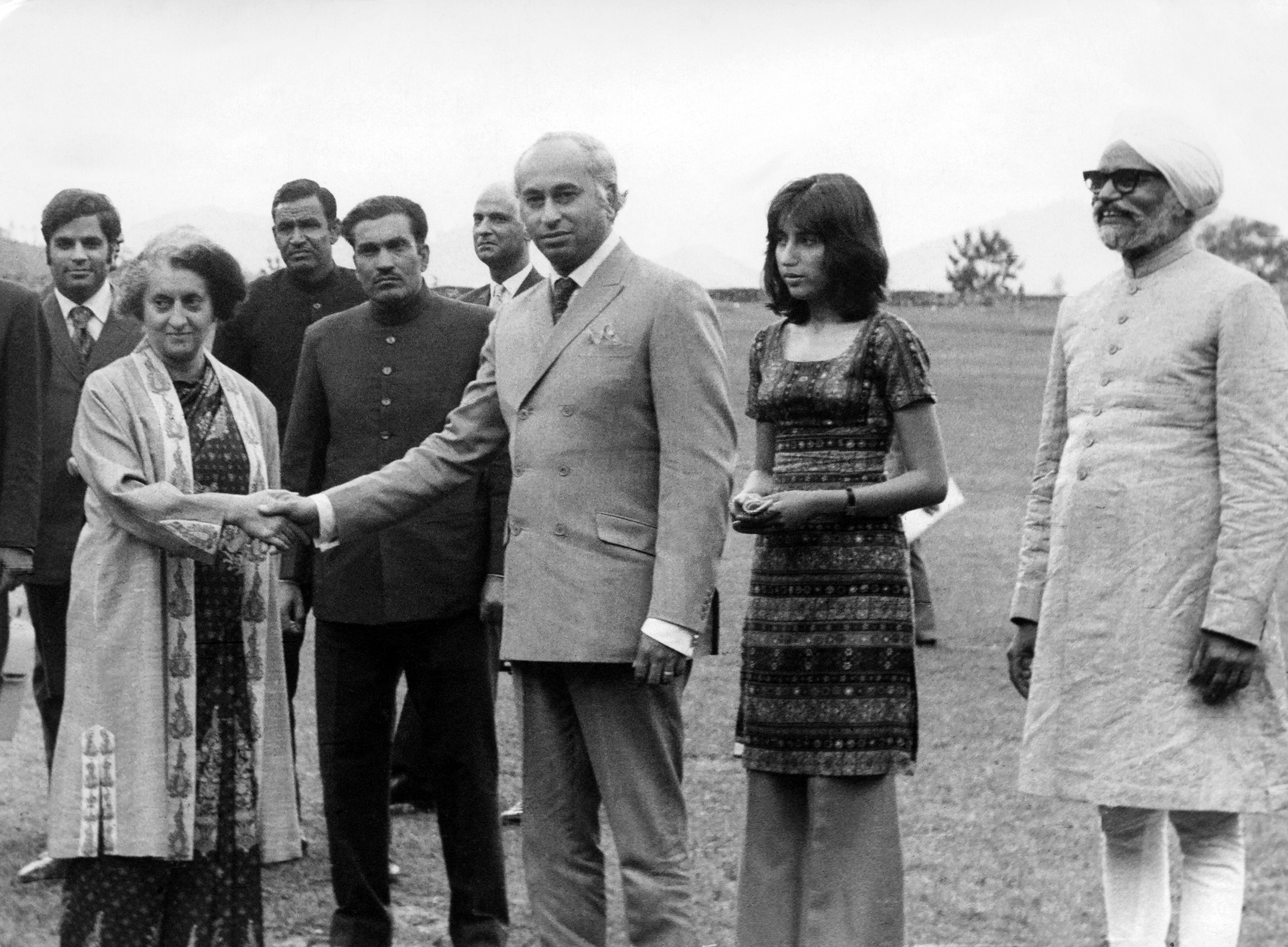 Le président pakistanais Zulfikar Ali Bhutto serre la main du Premier ministre indien Indira Gandhi le 28 juin 1972 à Shimla, la capitale d'été de l'Inde, sous le regard de sa fille Benazir Bhutto et du ministre indien des Affaires étrangères Swaran Singh. Bhutto s'est rendu en Inde pour rencontrer le premier ministre Indira Gandhi et négocier un accord de paix officiel et la libération de 93 000 prisonniers de guerre pakistanais. Les deux dirigeants ont signé l'accord de Shimla, qui engageait les deux nations à établir une ligne de contrôle au Cachemire et les obligeait à résoudre les différends de manière pacifique par des discussions bilatérales. (Photo par AFP/Getty Images)'s Prime Minister Indira Gandhi June 28, 1972 in Shimla, the summer capital of India, while his daughter Benazir Bhutto and Indian Foreign Minister Swaran Singh look on. Bhutto visited India to meet Prime Minister Indira Gandhi and negotiated a formal peace agreement and the release of 93,000 Pakistani prisoners of war. The two leaders signed the Shimla Agreement, which committed both nations to establish a Line of Control in Kashmir and obligated them to resolve disputes peacefully through bilateral talks. (Photo by AFP/Getty Images)