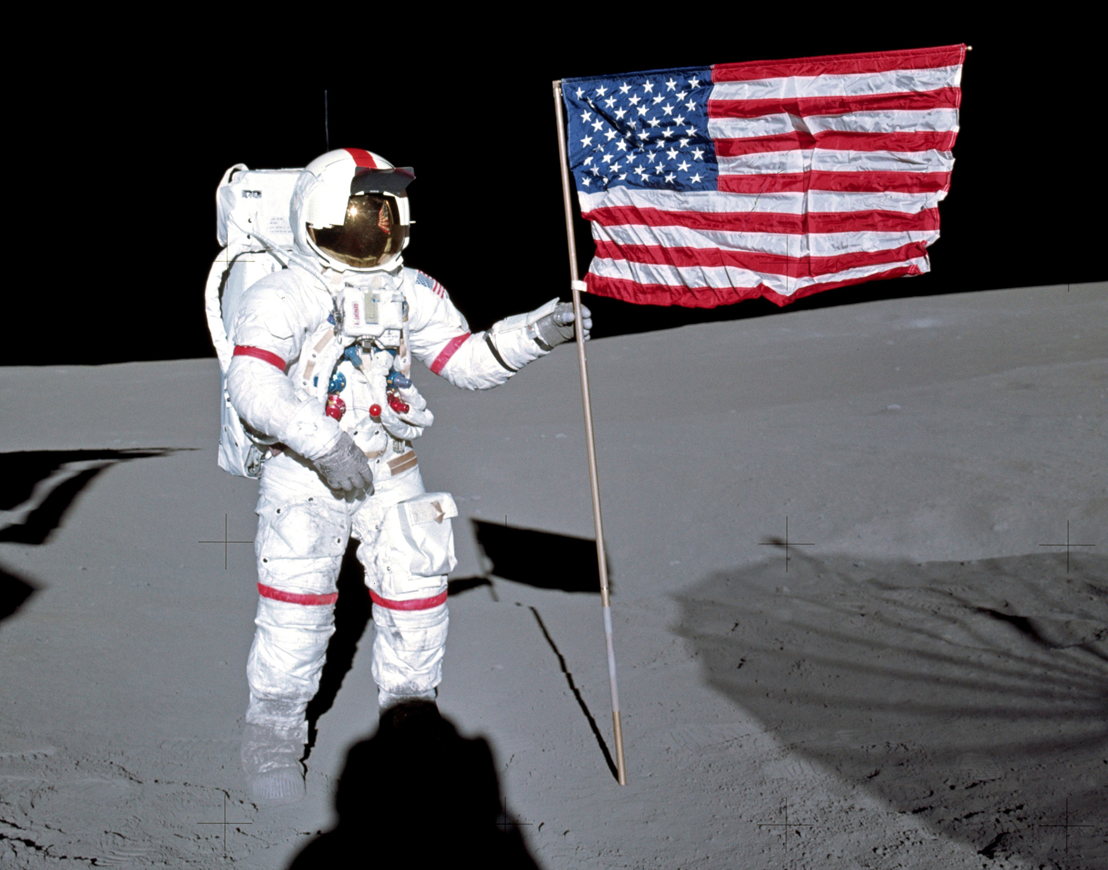 Alan Shepard planter Det Amerikanske flagget på månen.5. februar 1971: Astronaut Alan B. Shepard Jr., kommandør For Apollo 14 lunar landing mission, står ved DET AMERIKANSKE flagget på månens overflate under de første øyeblikkene av den første ekstravehikulære aktiviteten til oppdraget. Mens Shepard og astronaut Edgar D. Mitchell, lunar module-pilot, var å utforske Månen, astronaut Stuart A. Roosa, command module pilot, ble manøvrering Command Service Module i lunar bane. (NASA Photo)